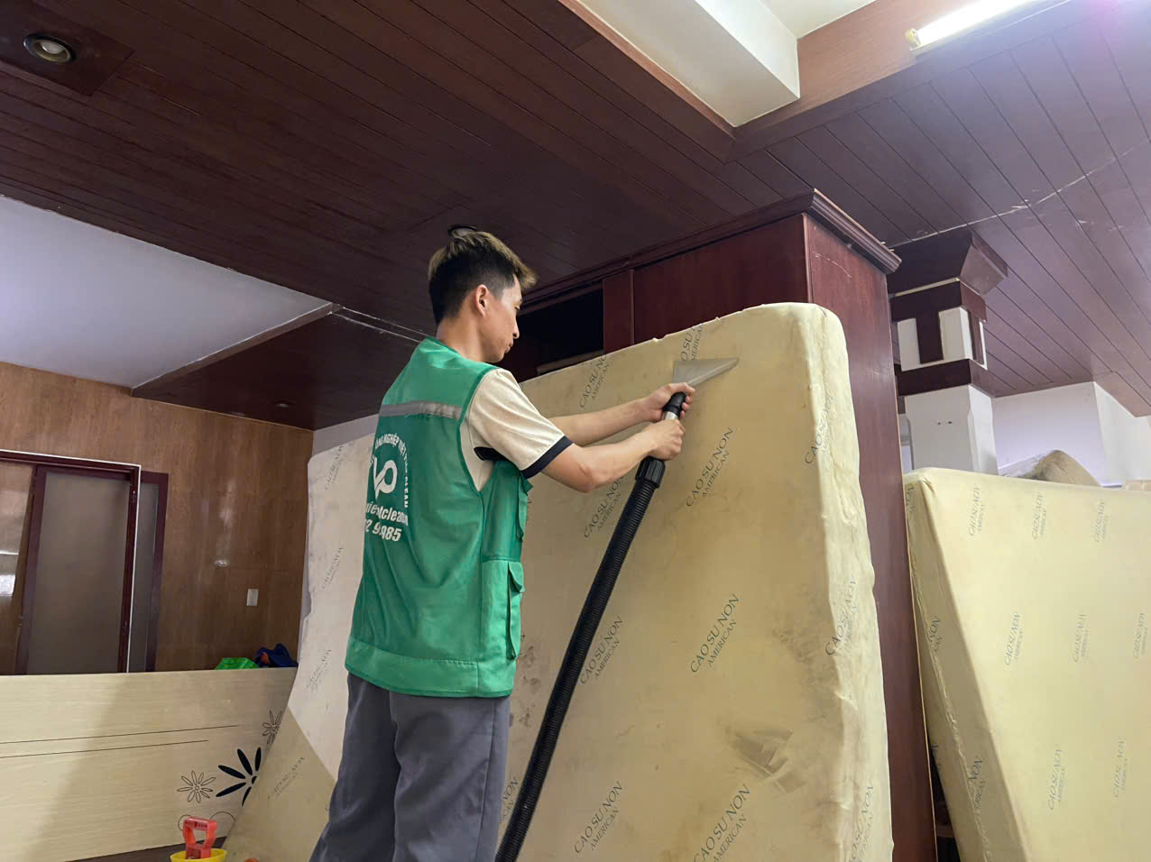 Nhân viên sử dụng máy hút công nghiệp để loại bỏ nước bẩn và bọt xà phòng